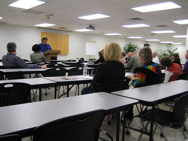 a woman lecturing to a group of adults