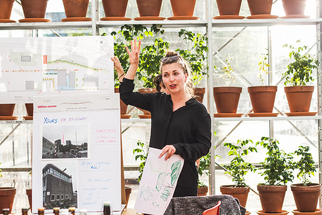 Photo of a woman standing near an easel giving a presentation.