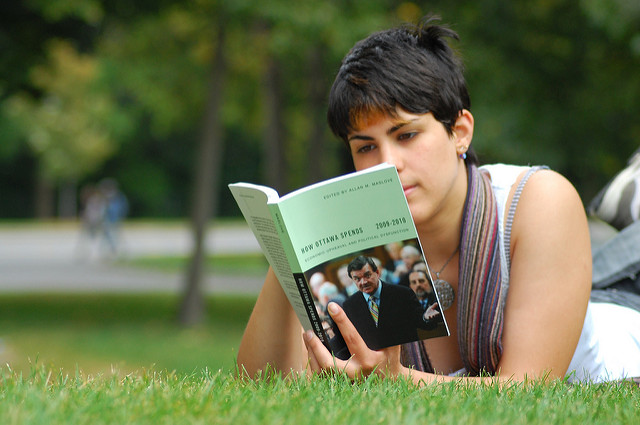  Foto de una mujer acostada en el césped, leyendo "How Ottowa Spends 2009-2010"