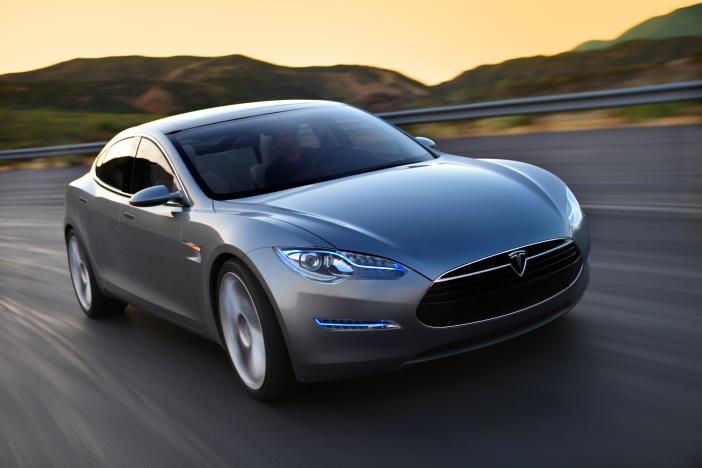 Photo of Tesla Model S being driven on a country road.