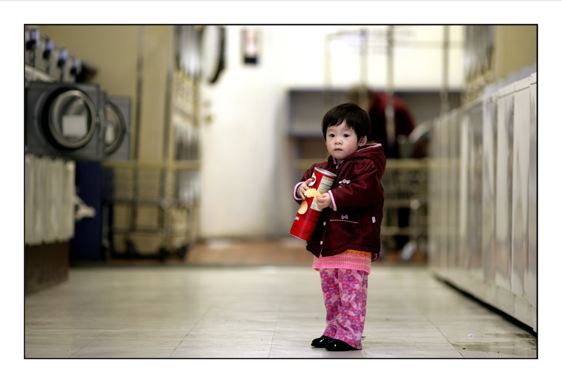 A small child clutching a can of Pringles.