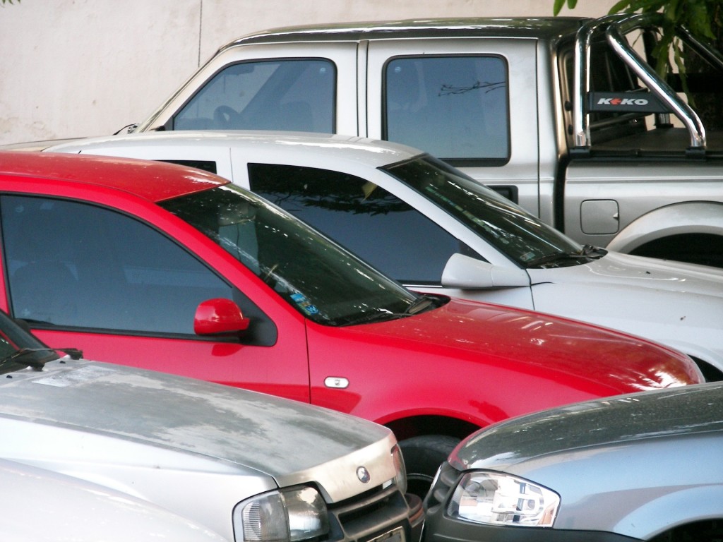 Cars packed tightly in a parking lot.