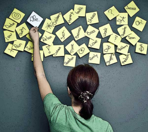 Woman standing in front of a wall of sticky notes