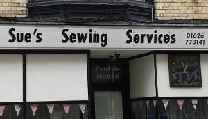 Photo of a store front.  The name of the store is "Sue's Sewing Services"