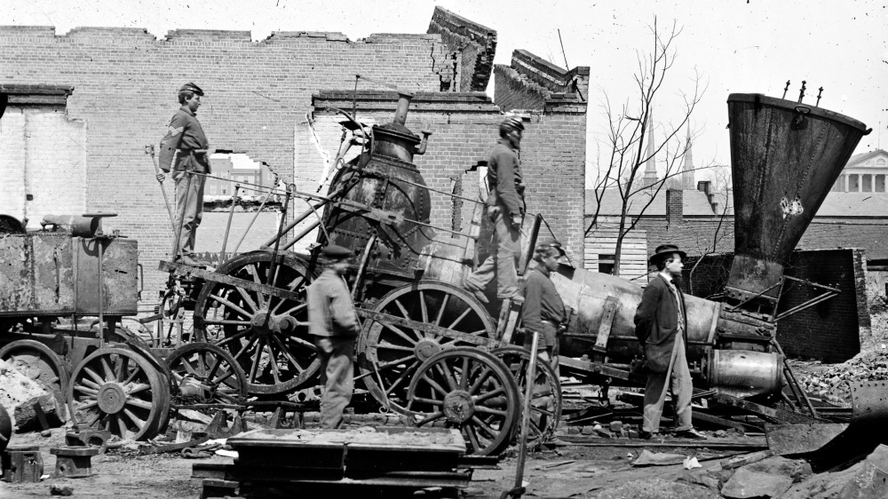 People on and around a broken train engine.