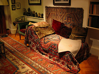  Esta fotografía muestra cómo era el famoso sofá psicoanalítico de Freud. El sofá está cubierto de tapices y almohadas, y la habitación está decorada con esculturas, libros y cuadros en la pared. (Prochaska Norcross, 2010). (crédito: Robert Huffstutter)