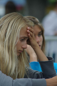 Woman with head on her hand, looking puzzled, in a classroom