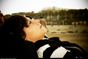 Woman lying on her back outdoors, in a reflective posture