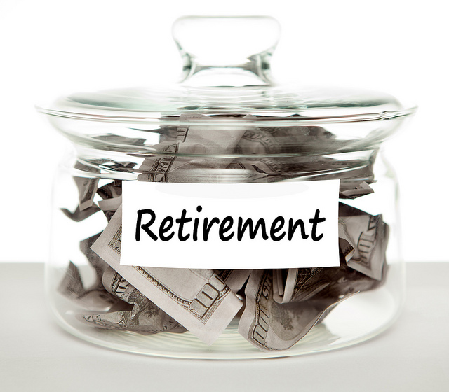 Glass jar labeled "Retirement." Inside are crumpled $100 bills