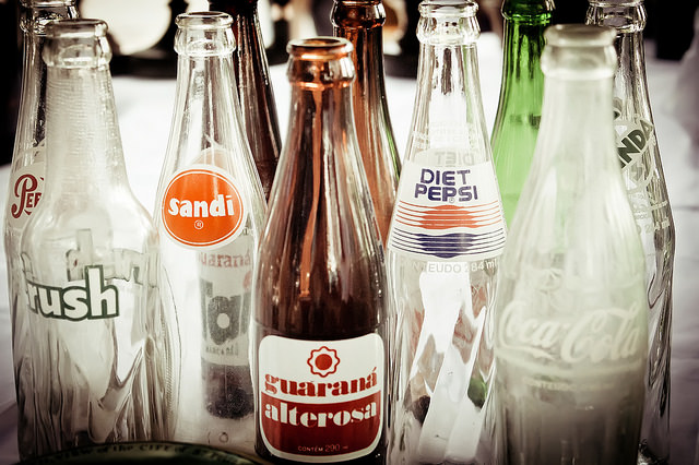 collection of empty glass soda bottles