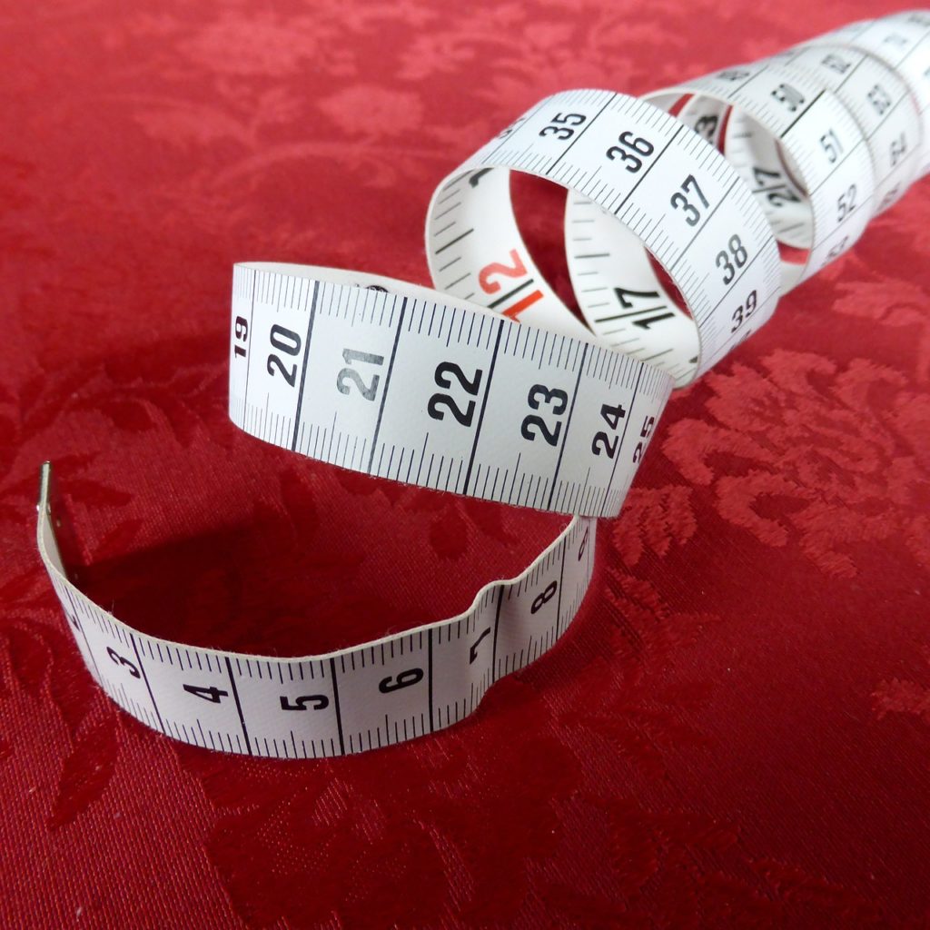 coiled measuring tape spiraling against a red background