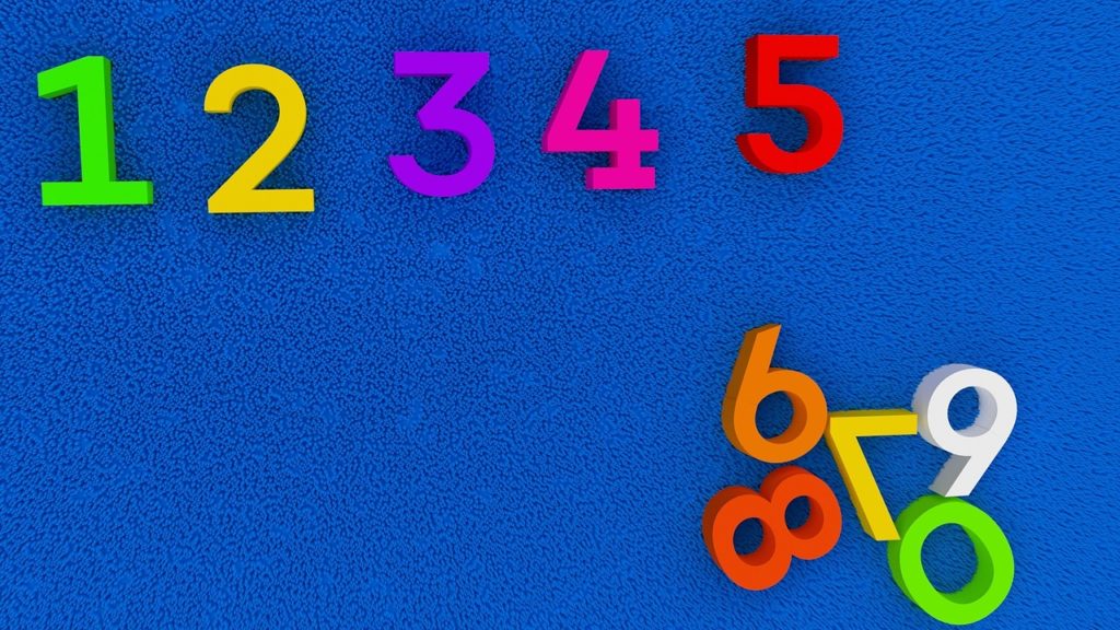 Blue background with magnetic numbers attached to it. 1-5 are arranged sequentially at the top, while remaining digits are clustered at the bottom right