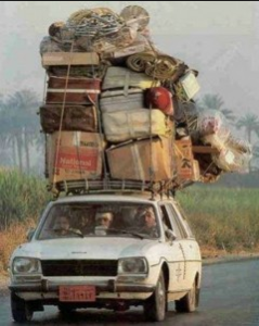 Car with boxes strapped to the top in a way that looks like they will fall off.