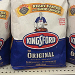 Photo of two bags of Kingsford-brand charcoal and some charcoal briquettes.