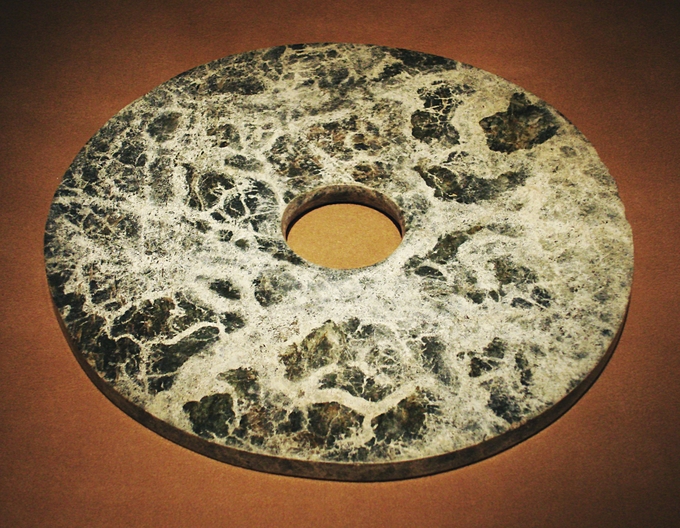 A disc that is black and milky white.