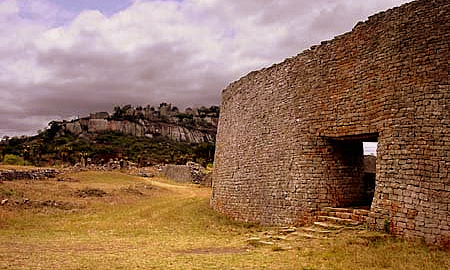 A large stone wall with a walkway through it.