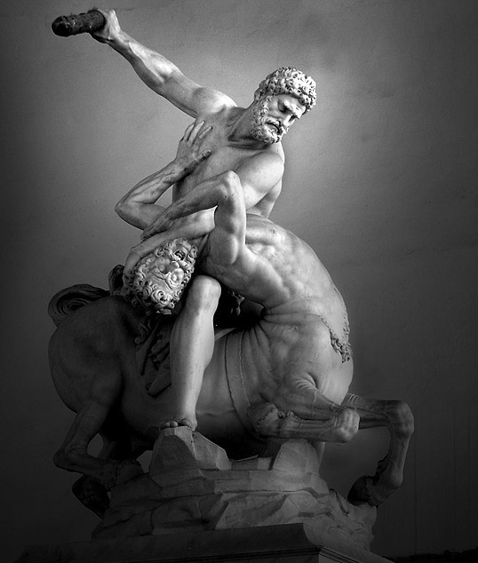 Sculpture depicts Hercules on top of the centaur Nessus, holding the centaur's head down. Hercules extends his right arm back, holding an object that he is using to beat Nessus.