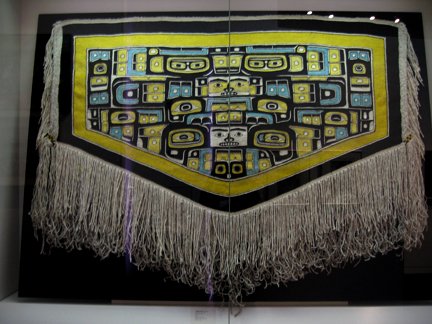This blanket has yellow, black, and blue designs with a fringe border.