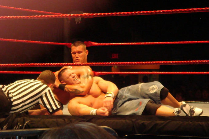 A picture of Randy Orton taking down "WWE Champion" John Cena with a choke-hold.