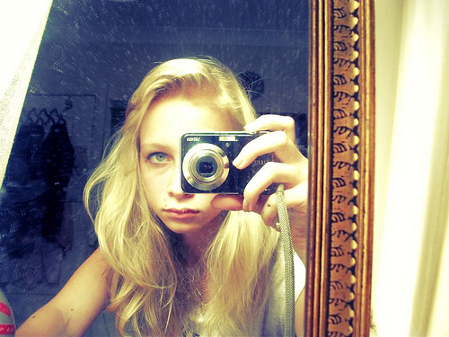A girl taking a picture of herself in a mirror.