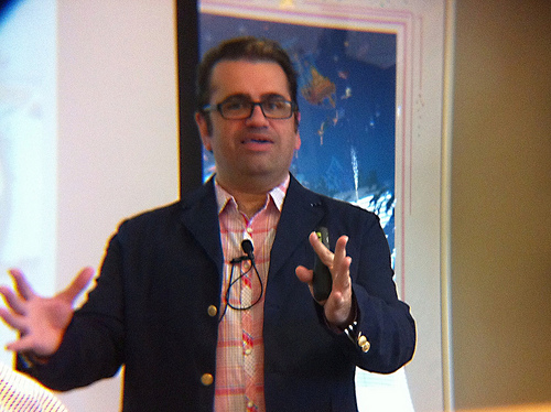 A man giving a speech and using his hands for emphasis.