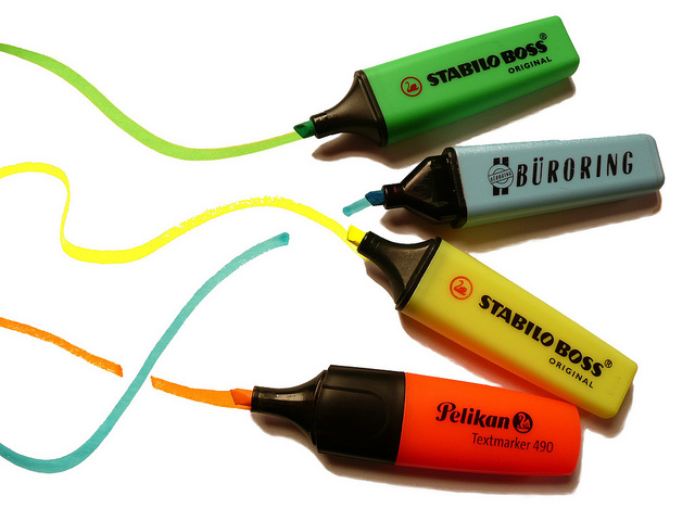 Four highlighters with marks on a piece of paper.