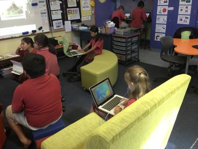 A classroom where students interact with each other in different groups