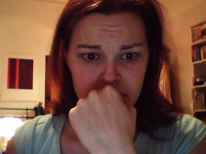 Photograph of a woman's face, showing disbelief with wide eyes, looking at something out of the image