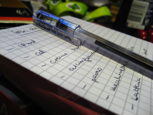Photo of a list handwritten on graphing paper, with a pen on top
