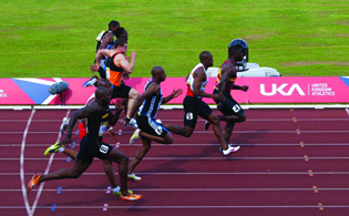 A photograph of 8 male runners in a track race.