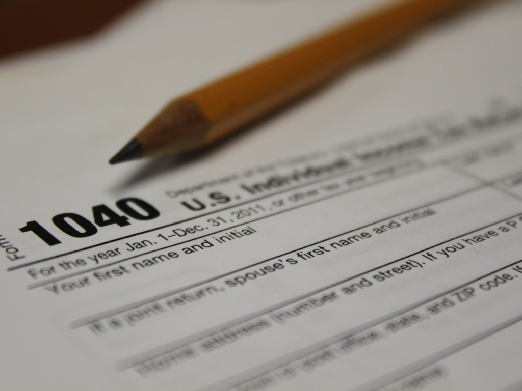 A U.S 1040 individual tax return form with a pencil lying on top of it