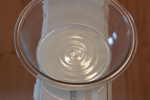 Photograph shows waves on the surface of a bowl of milk sitting on a box fan.