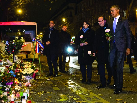 President Barack Obama, along with French president François Hollande and Paris mayor Anne Hidalgo, place roses on the makeshift memorial in front of the Bataclan concert hall, one of the sites targeted in the Paris terrorist attacks of November 13, 2015.