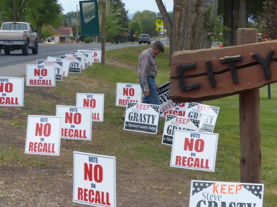Photo of yard signs along a busy road "Vote No on Recall"