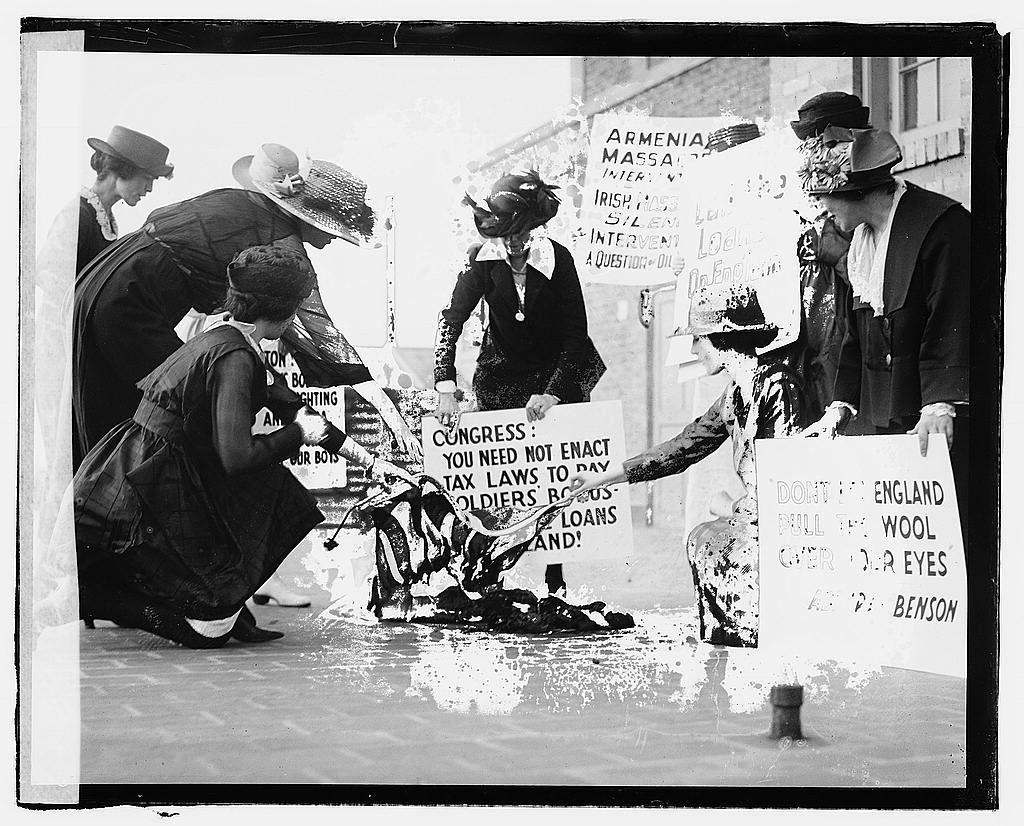 A group of women carrying signs against America’s support of the English against the Irish, burning a flag on the sidewalk, June 3, 1920; collection, Library of Congress at https://www.loc.gov/item/npc2007001720/