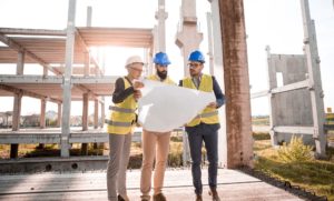 Three architects looking at a blueprint. 