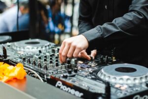 A DJ adjusts a knob on his turntable.