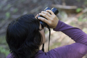 A woman looking through binoculars