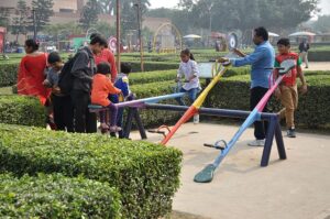 Children on a see-saw with their families