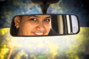 Woman looking in rearview mirror