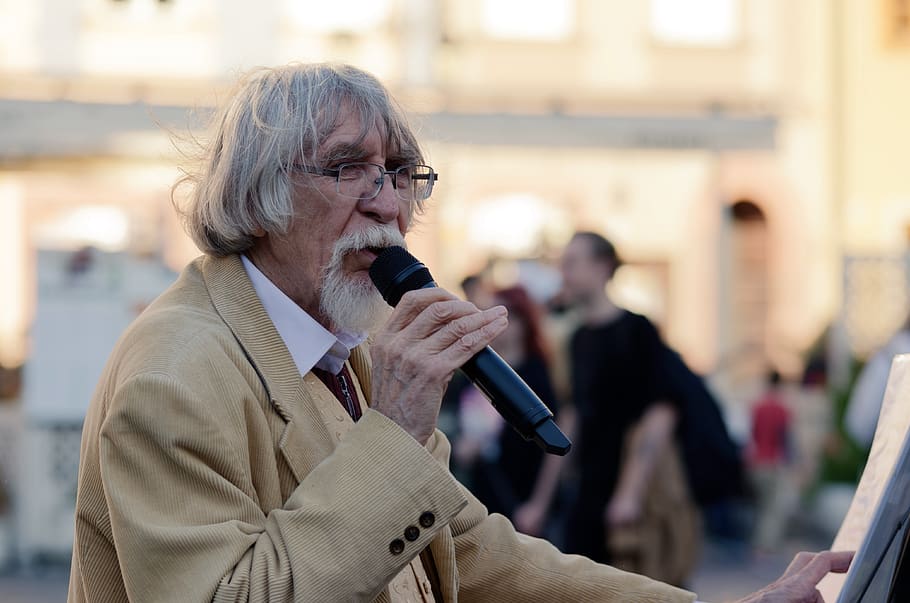 An older man speaking into a microphone