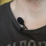 A lavalier mic clipped to a t-shirt collar.