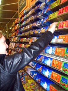 Person choosing a bar of chocolate from a wall of options