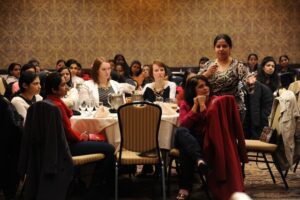 A woman speaking into a microphone at a lunch event