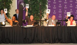 Judges in a competition holding up signs saying IN or OUT