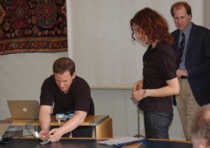 A person struggling to connect a computer to a projector