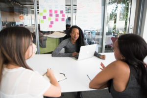 Three women talking at a conference table