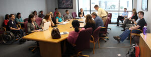 A large group of people meeting around a conference table