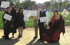 People in costume holding signs that say "Big Damn Heroes", "Shiny," "Rights for Vera," and "Sanity or Bust"