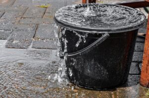 Water bucket overflowing with water.